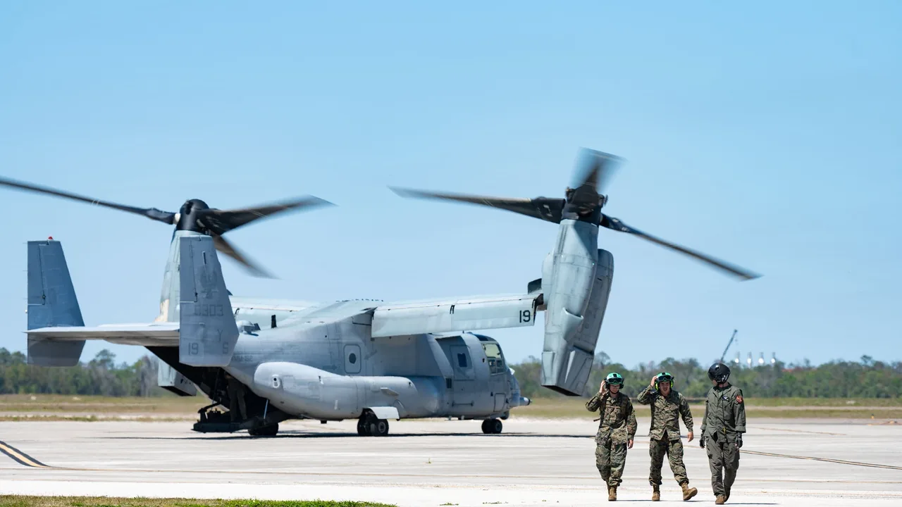米フロリダ州マクディル空軍基地の滑走路で、地上要員が見守る中エンジンを回して駐機する米海兵隊MV-22Bオスプレイの機体全体
